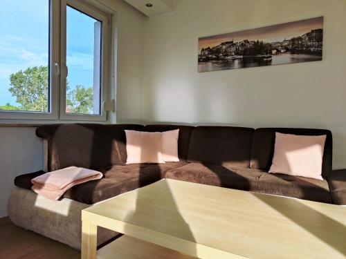 a living room with a brown couch and a table at Apartament F&J #12 in Toruń