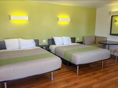 una habitación con dos camas y una mesa en American Inn, en Hawthorne