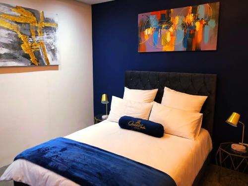 a bedroom with a bed with a blue wall at Queen Julie Lodge in Cape Town