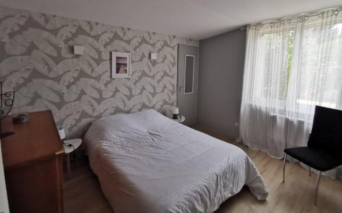 a bedroom with a bed and a desk and a window at Appt proche des vignes in Perrigny-lès-Dijon