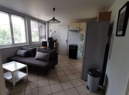 a living room with a couch and a kitchen at Appt proche des vignes in Perrigny-lès-Dijon