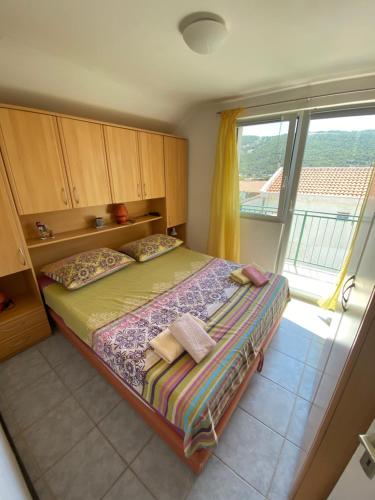 a bedroom with a bed and a large window at Apartment Marsela in Grebaštica