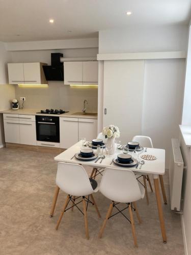 a kitchen with a white table and white chairs at Apartman Duna in Piešťany