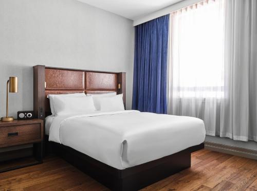 a bedroom with a large white bed and a window at The Metcalfe by Gray Collection in Ottawa