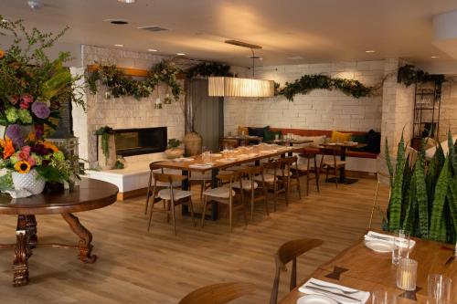 a dining room with tables and chairs and a fireplace at Toll House Hotel Los Gatos in Los Gatos