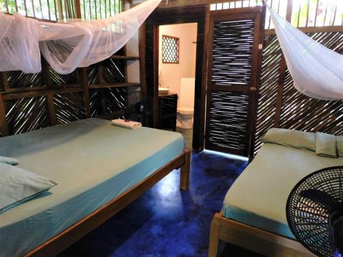 a bedroom with two beds and a net at Chez Oliv in Palomino