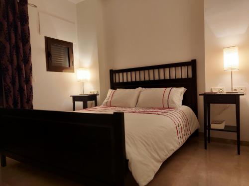 1 dormitorio con 1 cama grande, 2 mesas y 2 lámparas en Coto Real Resort en Manilva