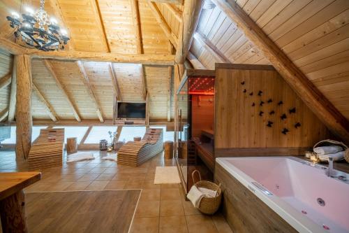 a large bathroom with a tub in a wooden ceiling at Hiša vina Cuk in Lendava