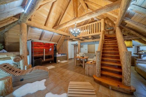 una sala de estar con una escalera en una cabaña de madera en Hiša vina Cuk, en Lendava