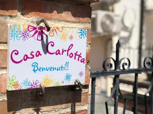 Et logo, certifikat, skilt eller en pris der bliver vist frem på Casa Carlotta