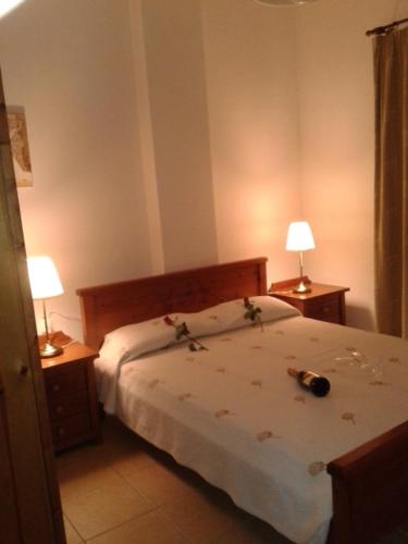 ein Schlafzimmer mit einem Bett und zwei Lampen an Tischen in der Unterkunft Kandania Apartments in Kántanos