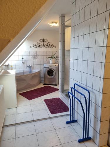 a bathroom with a tub and a sink and a washing machine at Haus Overbeck in Schneverdingen