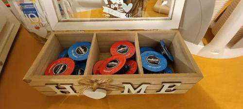 a box filled with four different colored buttons at Appartamento Beatrice in Villanova dʼAsti