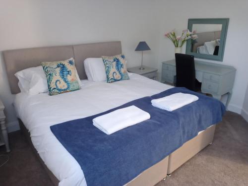 a bedroom with a large bed with two towels on it at 5 bedrooms sleeps 10-12 free wifi & parking garden in Lundin Links