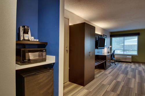 a room with a kitchen with a microwave and a desk at Holiday Inn Express Georgetown by IHG in Georgetown
