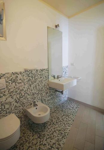 a bathroom with a sink and a toilet and a mirror at Holiday home Isola Rossa in Isola Rossa