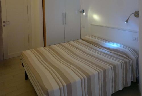 a bed in a room with a striped sheet on it at Holiday home Isola Rossa in Isola Rossa