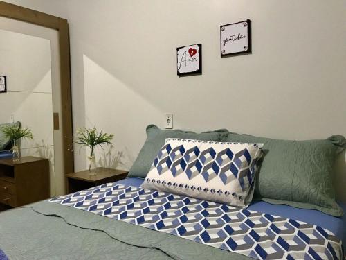 a bedroom with a bed with a pillow and a mirror at Casa próxima às Cataratas e Argentina/WIFI/garagem in Foz do Iguaçu