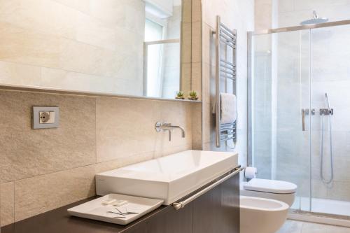 uma casa de banho com um lavatório, um WC e um chuveiro em Rosselli 13 Milan Apartment em Milão