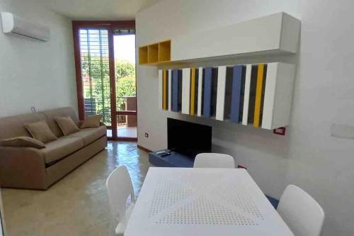 sala de estar con sofá, mesa y sillas en Gli appartamenti di Francuzzo, en Teulada
