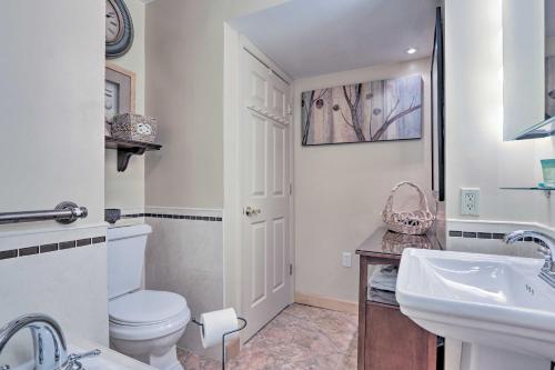 a white bathroom with a toilet and a sink at Hilton Head Condo with Pool and Beach Access! in Hilton Head Island