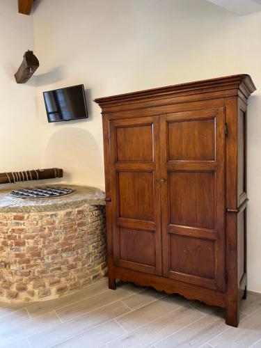 a bedroom with a wooden cabinet next to a brick wall at Il Baco Da Seta in Manta