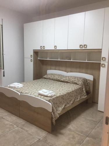 a bedroom with a large bed with white cabinets at Appartamento dei nonni di Gio e Cry in Sperlonga