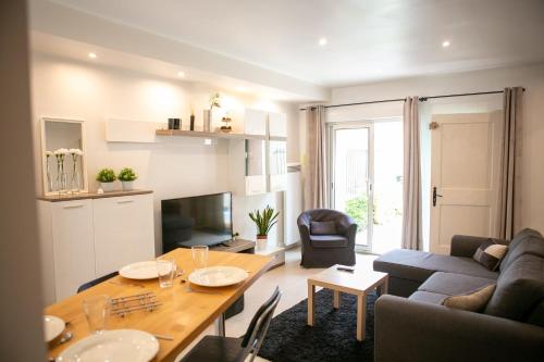 een woonkamer met een tafel en een bank bij Appart'Hôtel L'Arbonnaise - Calme & Chic in Arbonne