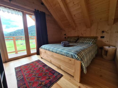 a bedroom with a bed and a large window at Chalet Camporosso in Camporosso in Valcanale