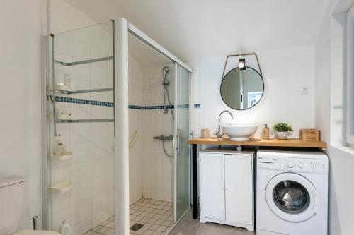 a bathroom with a shower and a washing machine at CABANA & LES PORTES DE LA FORÊT D' ORLÉANS in Nevoy