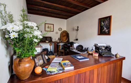 un escritorio con un jarrón de flores encima en Casa da Padaria, en Piódão