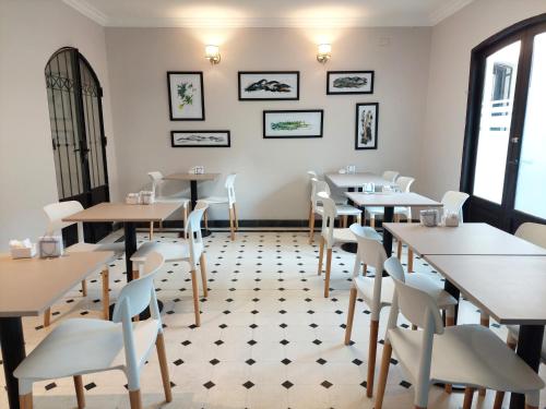 een eetkamer met tafels en witte stoelen bij Posada del Marques Salta in Salta