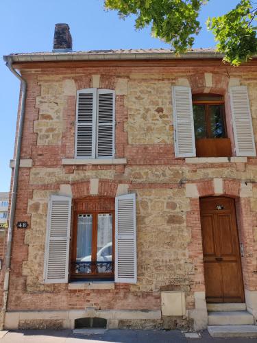 un ancien bâtiment en briques avec des fenêtres et une porte dans l'établissement studio Le 46 bis, à Châlons-en-Champagne