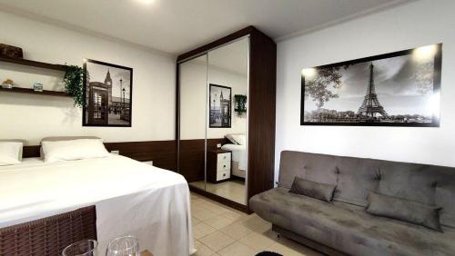 a bedroom with a bed and a couch at Lindos Studios Centro/Wifi/Garagem in Foz do Iguaçu