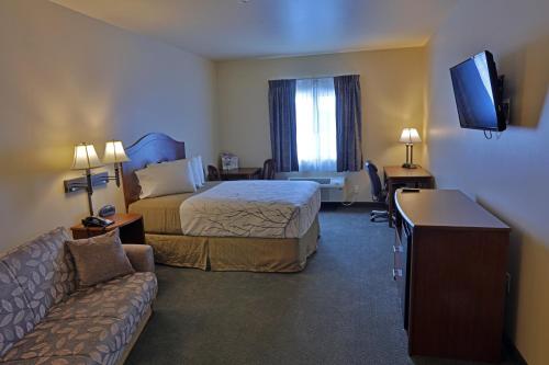 a hotel room with two beds and a couch at Sandhills Guest House Motel in Atkinson