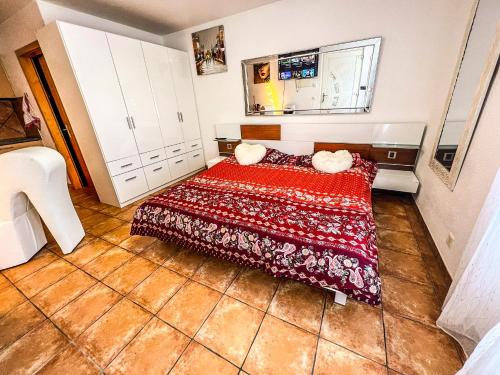 - une petite chambre avec un lit et une couverture rouge dans l'établissement Studio romantique vue sur camping, à Saxon