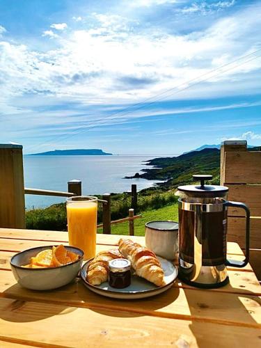a table with a breakfast of croissants and orange juice at Byre 7 Aird of Sleat in Aird of Sleat