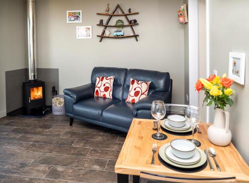 a living room with a leather couch and a table at Byre 7 Aird of Sleat in Aird of Sleat
