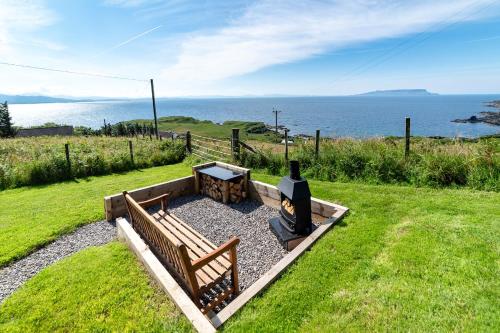 a park bench with a table and a grill at Byre 7 Aird of Sleat in Aird of Sleat