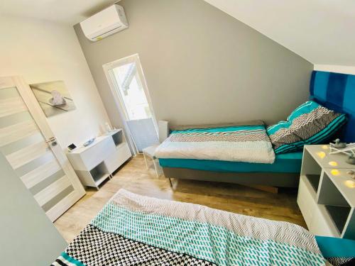 um pequeno quarto com uma cama e um espelho em "Blue Sun" Apartament 11B HorizonPark Dziwnòwek em Dziwnówek