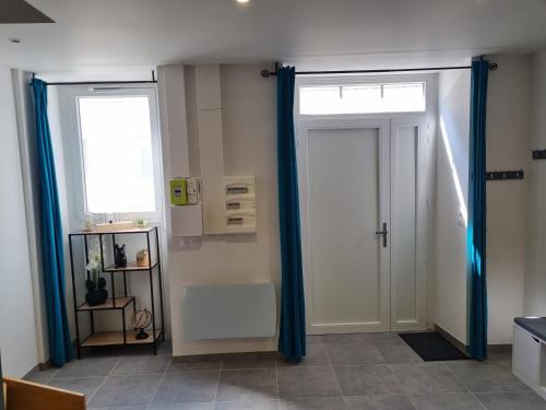 2 Türen in einem Zimmer mit blauen Vorhängen in der Unterkunft Superbe logement T3 en duplex. in Saint-Gaudens