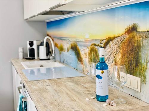 uma garrafa de vinho sentada num balcão na cozinha em "Blue Sun" Apartament 11B HorizonPark Dziwnòwek em Dziwnówek