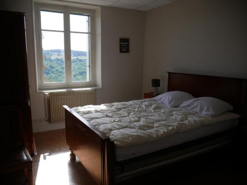 Ce lit se trouve dans une chambre dotée d'une grande fenêtre. dans l'établissement CHEZ GRAND MAMIE, à Polignac