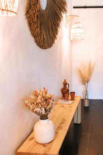 a wooden table with a vase of flowers on it at Monte do Pomar in Redondo