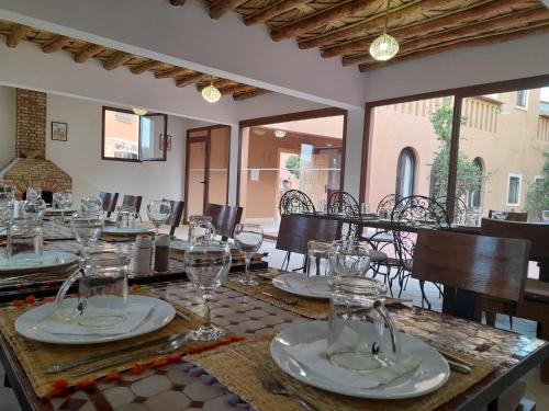 un comedor con una mesa con gafas. en Kasbah La Cigogne, en Aït Ben Haddou