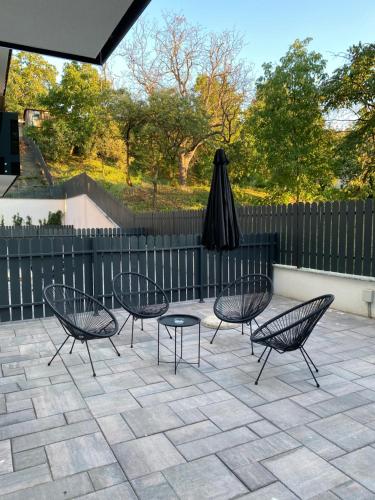 a patio with four chairs and a table and an umbrella at Opera Apartments in Cluj-Napoca