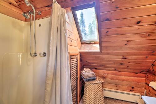 a bathroom with a shower and wooden walls and a window at Lake Placid Chalet Deck and Forest Views! in Lake Placid