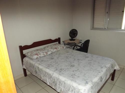 ein Schlafzimmer mit einem Bett und einem Tisch mit einem Stuhl in der Unterkunft Apartamento inteiro para até 5 pessoas in Campinas