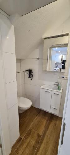 a bathroom with a toilet and a sink and a mirror at The Modern Cave Lodge - ComfyHome Apartments Stuttgart in Stuttgart