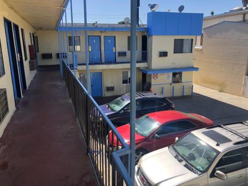 two cars parked in a parking lot in front of a building at King Castle Motel in Los Angeles